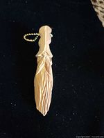 Full view of carved wood keychain front side with ball chain