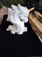Front left view showing unicorn profile, gold horn, mane detail