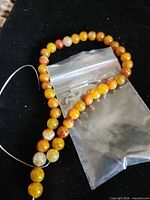 Full strand of round fire agate beads with plastic bag