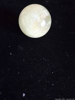 front view of pale green quartz sphere on black background