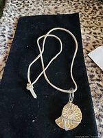 Front view of pendant on cord displayed on black fabric