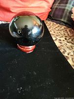 Onyx sphere on wooden stand, glossy finish visible
