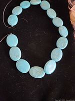 Full strand of turquoise beads on black background