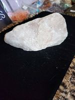 Oblique view of entire rose quartz stone on black background