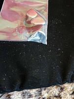 Two stones inside small plastic bag on dark fabric