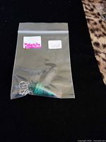 Pendulum in plastic bag showing chain and stone