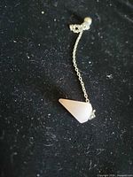 Close view of rose quartz pendulum attached to chain