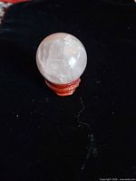 Front view of rose quartz sphere on stand