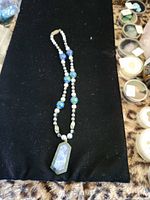 Full view of necklace laid flat showing pendant and bead arrangement
