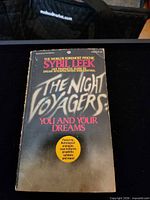 Front cover of the paperback showing title, author and feature burst