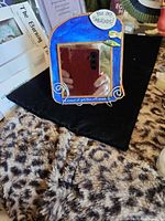 Front view of mirror showing frame color, speech bubble text and stand