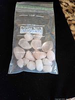 Bag containing rose quartz stones with measurement markings visible