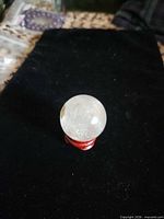 Quartz sphere on red stand against black background