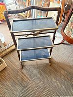 Front view showing three glass-shelf tiers and faux bamboo metal frame