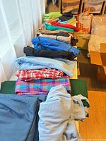 Row of assorted folded fabric pieces in multiple colors and patterns on table