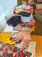 stack of assorted solid and printed fabrics on table