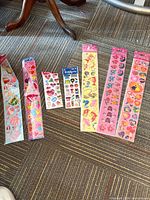 Selection of long strip and small sticker sheets laid out showing various themes