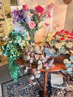 Multiple artificial plants on round table showing overall lot