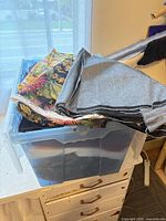 Clear bin filled with folded fabric pieces