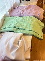 Green, lavender and white fabric folded on table