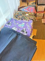Row of assorted folded fabrics on table