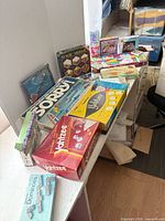 Overview of stacked board games and puzzles on table