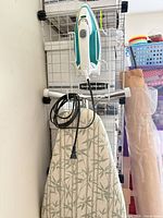 Ironing board with bamboo-pattern cover, clothes iron on wire rack