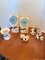 All seven ceramic kitchen pieces grouped on table