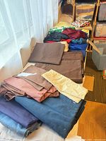 Table with stacked brown, navy, burgundy, yellow fabrics and coloured mesh pieces