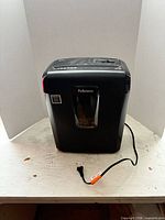 Front view of Fellowes shredder showing window and attached power cord