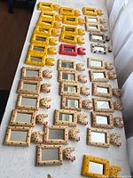 Tabletop view of rows of small hand-painted wooden mirrors