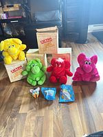 Group view: four Kodak plush on crates, Furby figure, two sealed McDonald’s toys
