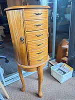 Full view of armoire closed on stand