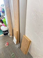 Vertical side panels and stacked shelf panels leaning against wall