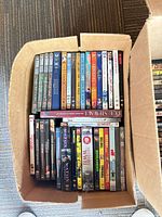 Box of Disney and assorted movie DVDs, top view