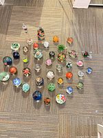 Top-down view showing entire grouping of about forty paperweights