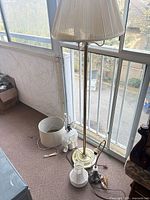 Group view showing all three lamp pieces: brass floor lamp, ceramic elephant lamp base with nearby shade, ornate metal lamp base