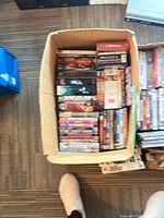 Two boxes containing DVDs and VHS tapes