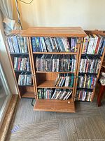 Front view of oak finish media cabinet loaded with DVDs and game discs