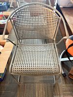 Front view of one chair showing lattice pattern, arms, seat
