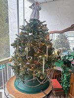 Front view of decorated rotating tree on green base