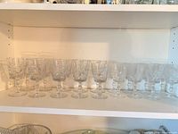 Front view of all 12 crystal wine glasses on shelf