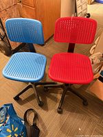 Blue and red IKEA task chairs side by side showing seats, backs and caster bases