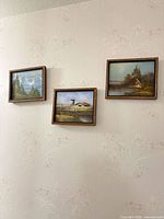 All three framed landscape paintings displayed on wall