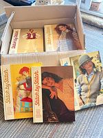 Box containing multiple Stitch by Stitch hardcover books with several volumes displayed in front