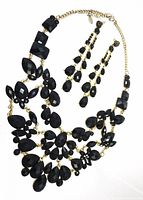 Necklace laid in arc with earrings above showing overall design and proportion