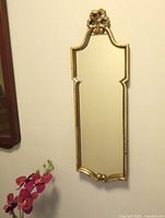 Full view of gilded rectangular mirror on wall