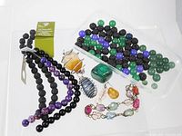 Full lot overview showing bead strands, loose beads, wire-wrapped pendants, malachite stone, bracelet and earring