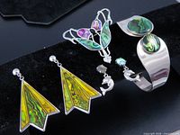 Overall lot view showing brooch, two pairs earrings, clamp bracelet