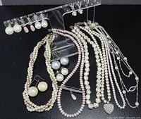 Lot overview showing necklaces, earrings on stand, brooch